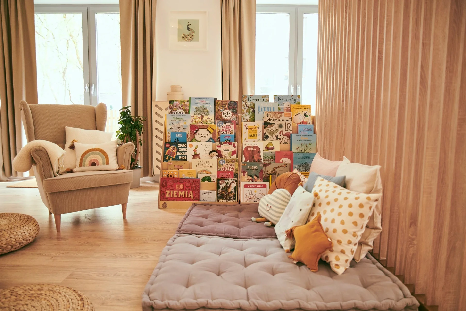 A cosy BLISKO reading corner with an armchair, book display and floor cushions.